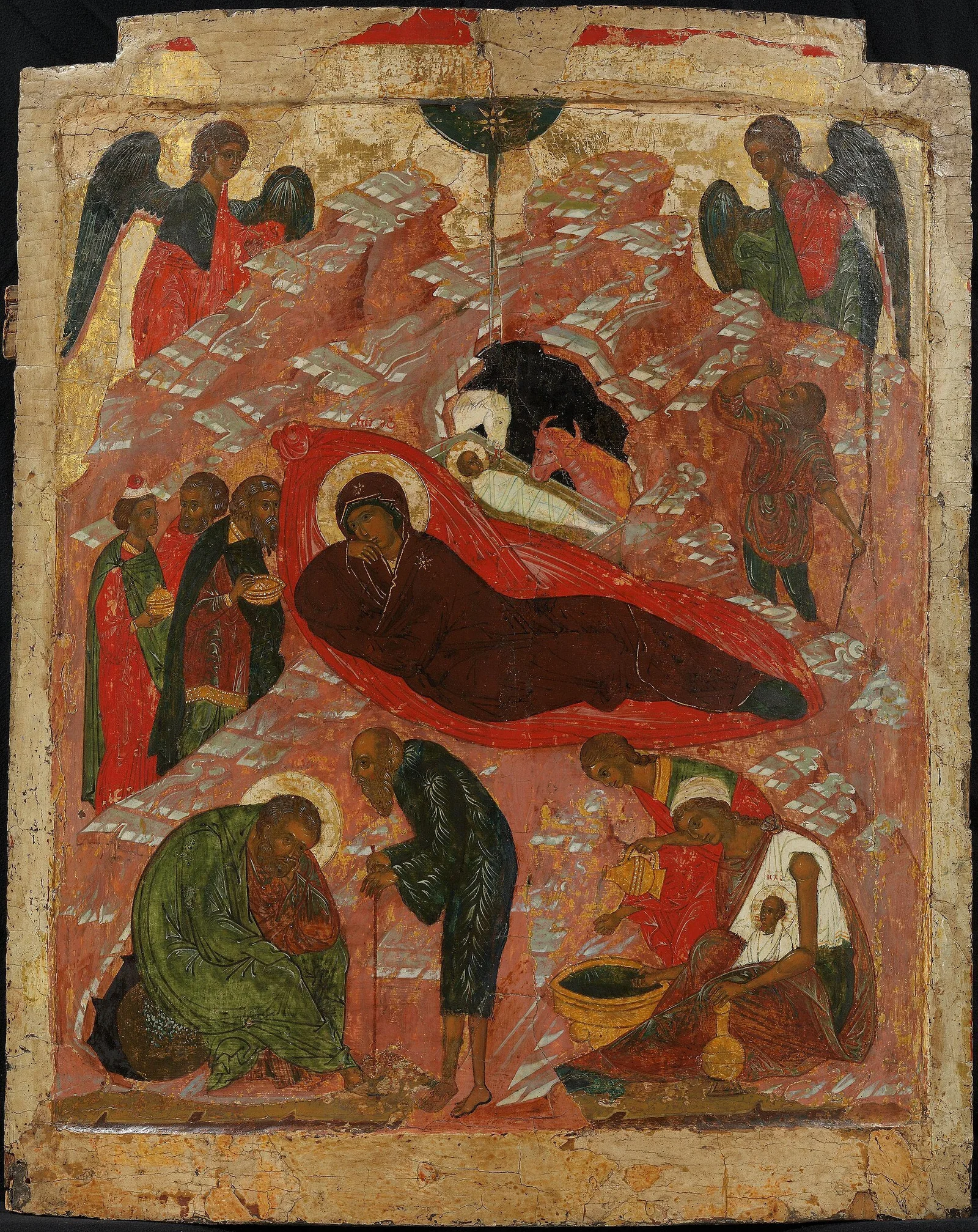 Novgorod-school icon of the Nativity with bright red accents, white-highlighted rocky hills, angels above and the washing of the Child below